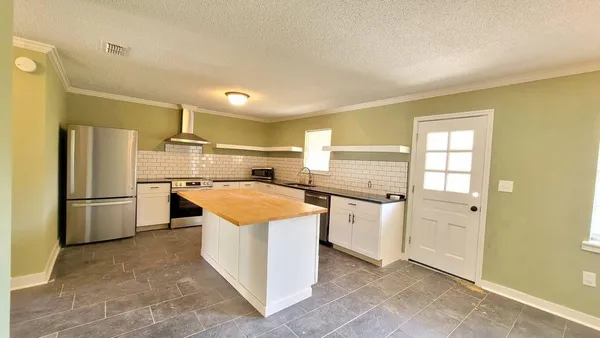 a kitchen with a refrigerator a oven a sink dishwasher and white cabinets with wooden floor