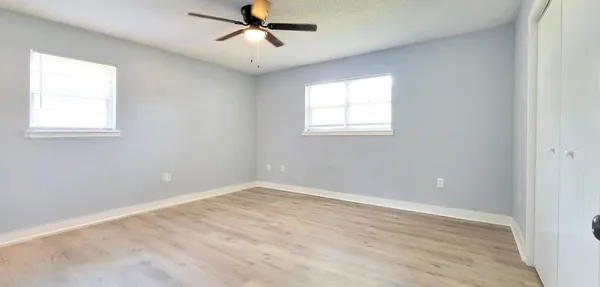 an empty room with a window and a fan