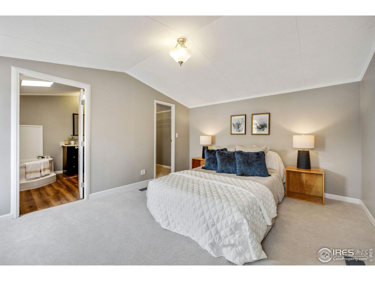 517 East Trilby Road, Unit 102 Fort Collins, CO 80525 - Photo 9 of 19 a bedroom with a large bed and a chandelier