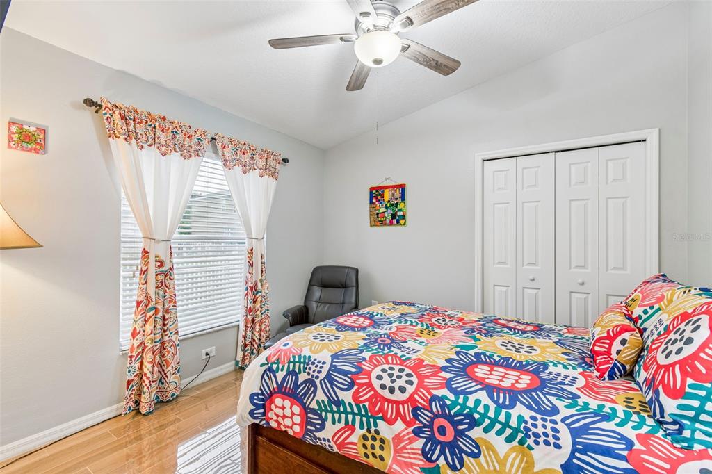 2006 Meadow Rue Court Trinity, FL 34655 - Photo 28 of 96 a bedroom with a bed and a chandelier
