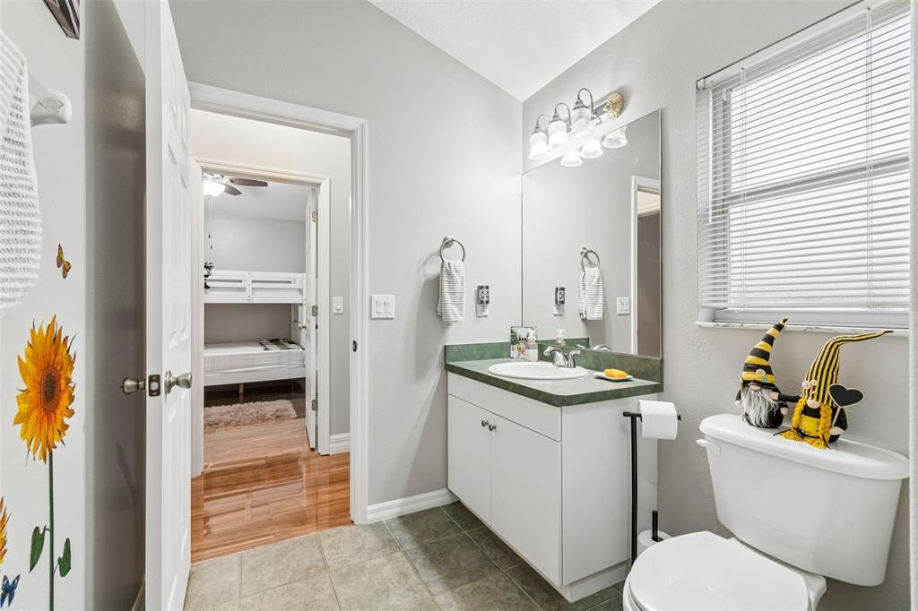 2006 Meadow Rue Court Trinity, FL 34655 - Photo 31 of 96 a bathroom with a granite countertop toilet a sink and a mirror