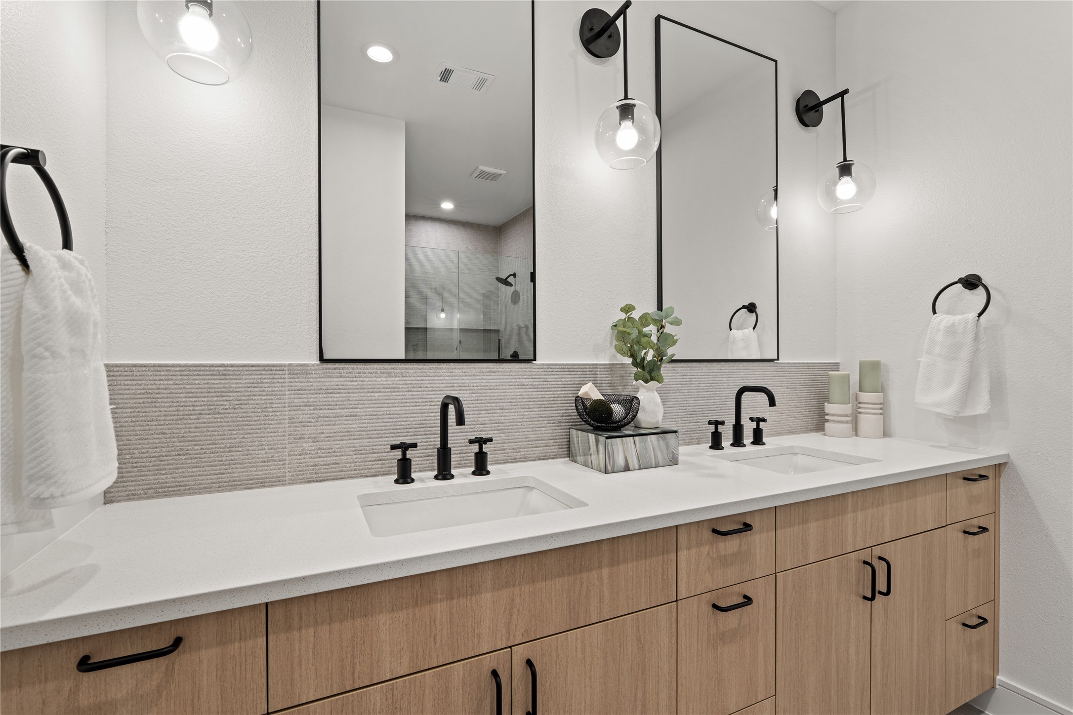 8019 Grandview Street Houston, TX 77051 - Photo 21 of 34 Primary bathroom – double vanity with wood cabinetry, white countertops, black fixtures, and modern sconces.