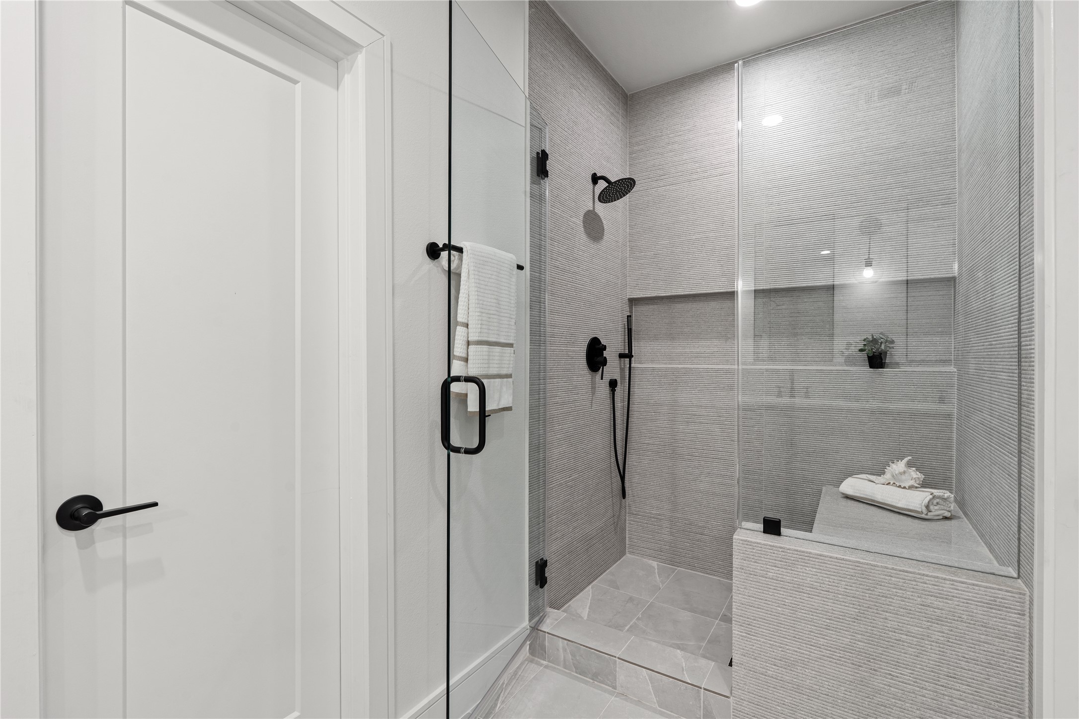 8019 Grandview Street Houston, TX 77051 - Photo 22 of 34 Walk-in shower – glass enclosure with bench seating, tiled walls, and matte black fixtures.