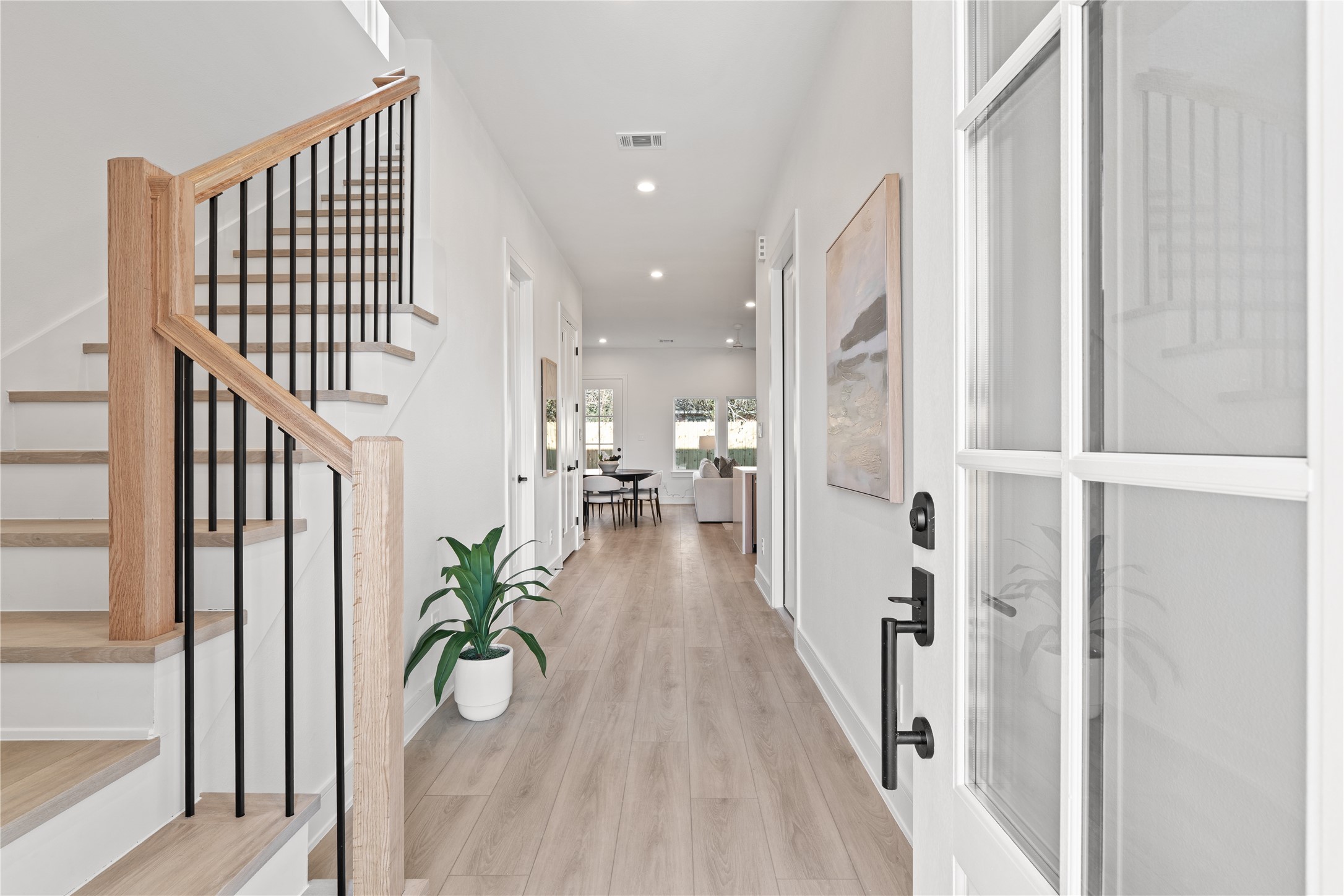 8019 Grandview Street Houston, TX 77051 - Photo 4 of 34 Bright entry hallway with wood-look flooring, modern staircase, and an inviting open feel