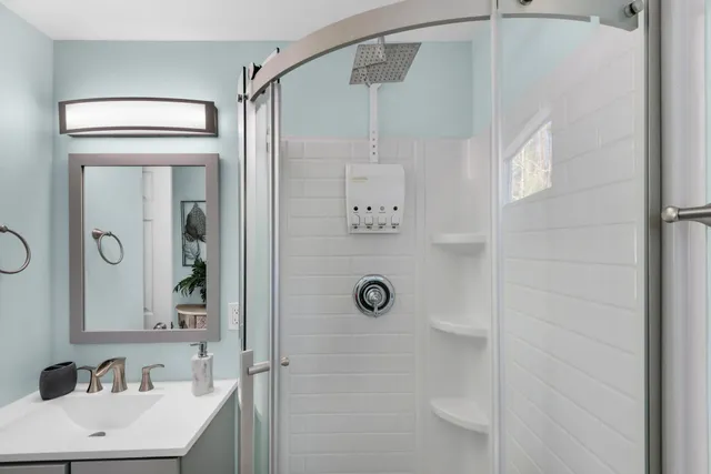 a bathroom with a shower a mirror and a sink