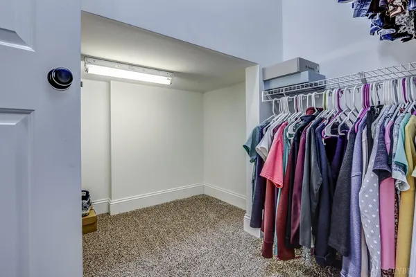 a view of walk in closet with clothes