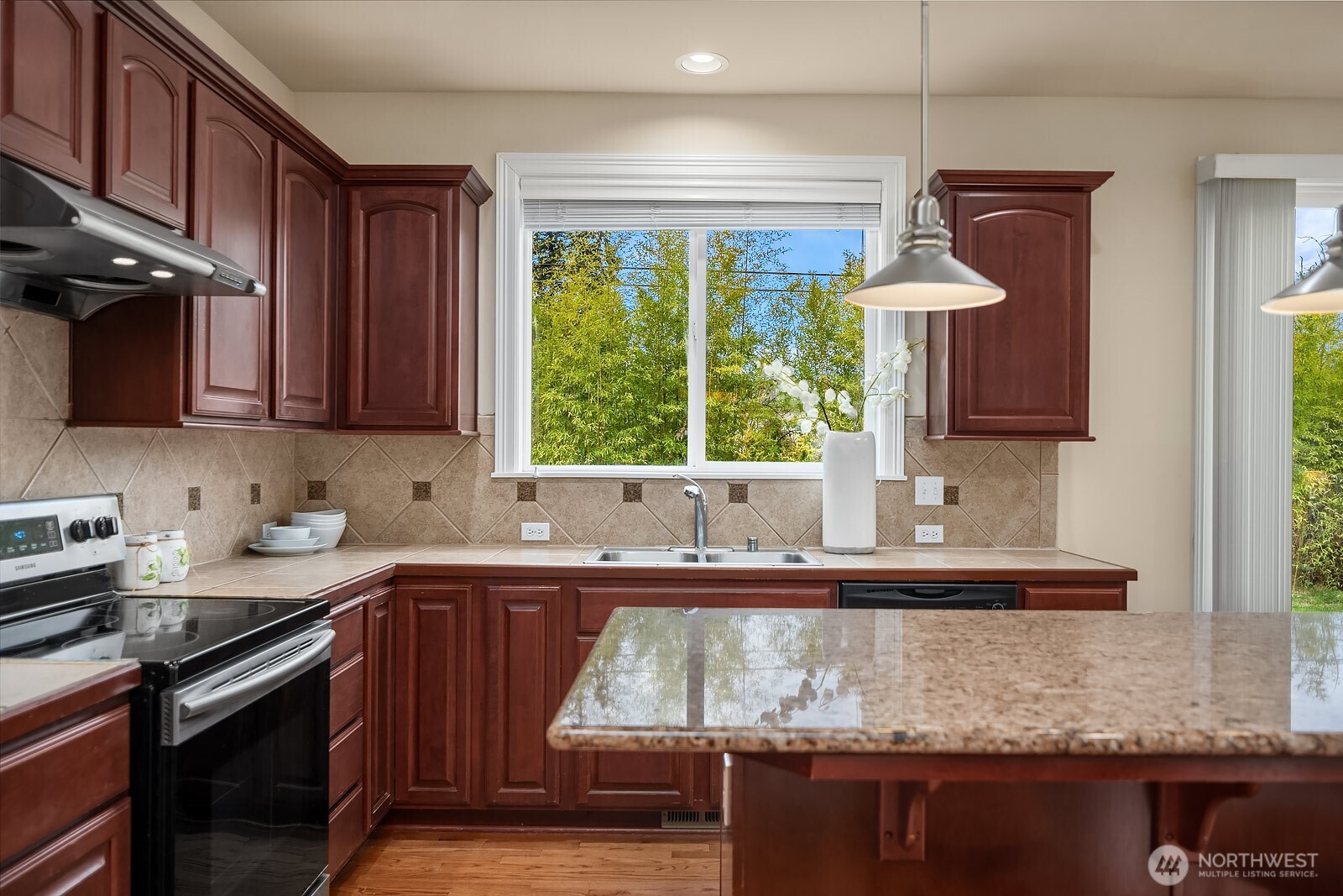 5504 Northeast 13th Place Renton, WA 98059 - Photo 12 of 36 a kitchen with stainless steel appliances granite countertop a sink a stove and a microwave
