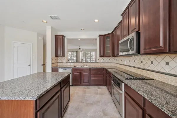 a kitchen with stainless steel appliances granite countertop a sink and dishwasher a stove with wooden floor