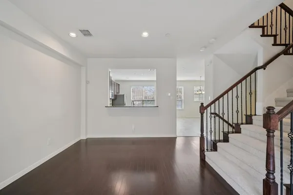 a view of a hallway with wooden floor and staircase