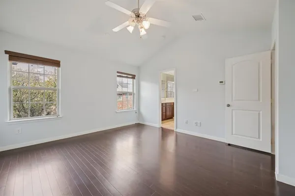a view of an empty room with a window and wooden floor