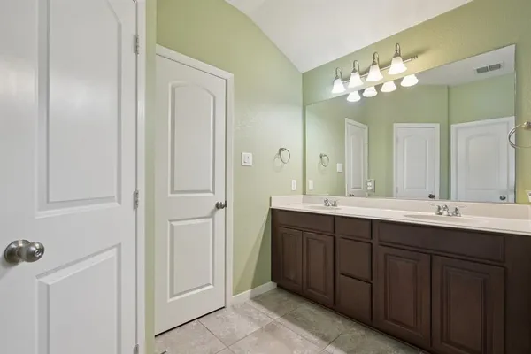 a bathroom with a double vanity sink and a mirror