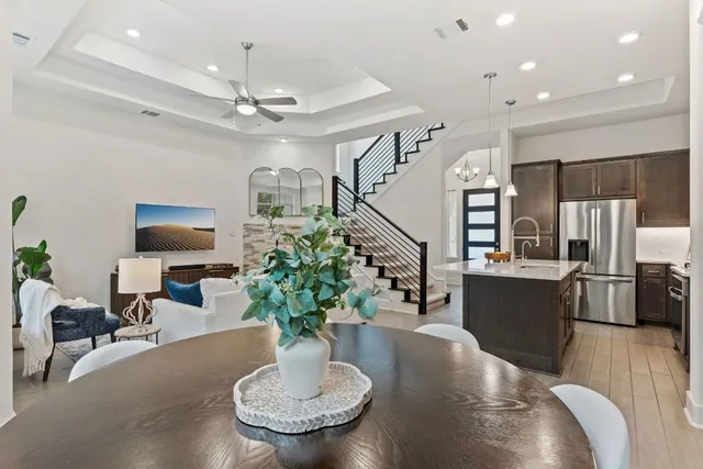 a living room with furniture potted plant and kitchen view