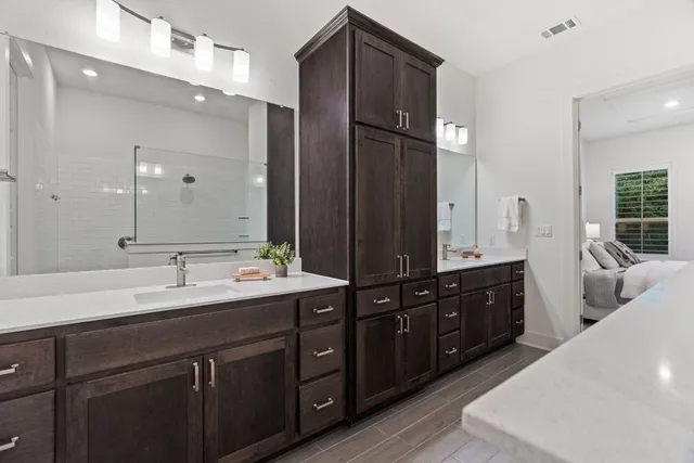 a spacious bathroom with a double vanity sink and mirror