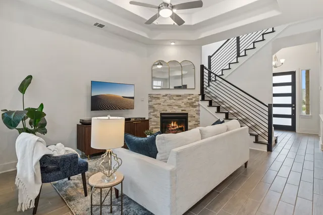a living room with furniture a flat screen tv and a fireplace