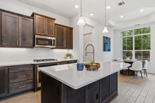 a kitchen with a sink a stove and chairs