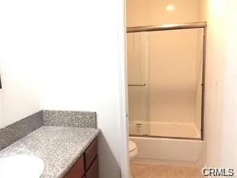 a bathroom with a granite countertop shower and a sink