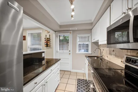a kitchen with granite countertop a sink and a stove top oven