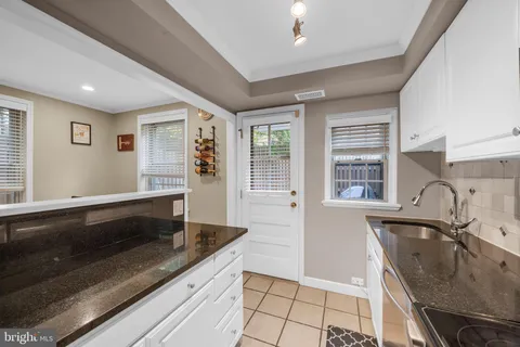 a kitchen with granite countertop a refrigerator and a stove top oven