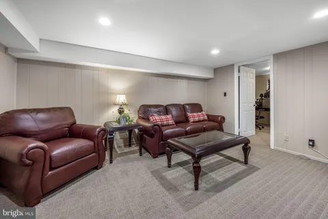 a living room with furniture a flat screen tv and bookshelf