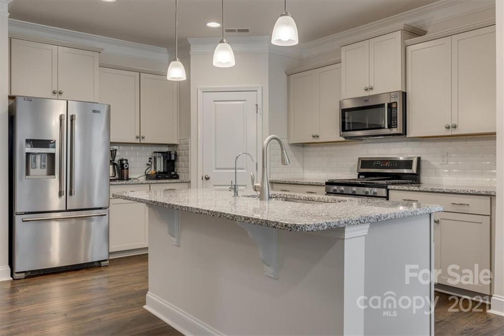 1007 Lydney Circle Waxhaw, NC 28173 - Photo 11 of 46 a kitchen with stainless steel appliances granite countertop a refrigerator a stove a sink and white cabinets