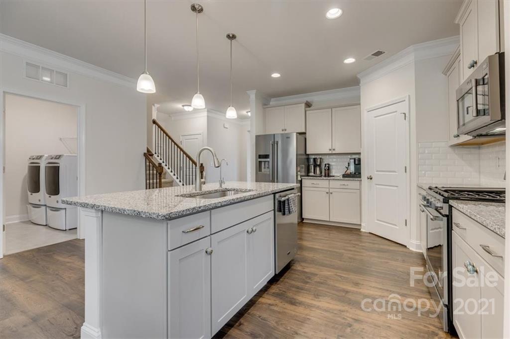 1007 Lydney Circle Waxhaw, NC 28173 - Photo 12 of 46 a kitchen with stainless steel appliances granite countertop a sink a stove and a refrigerator