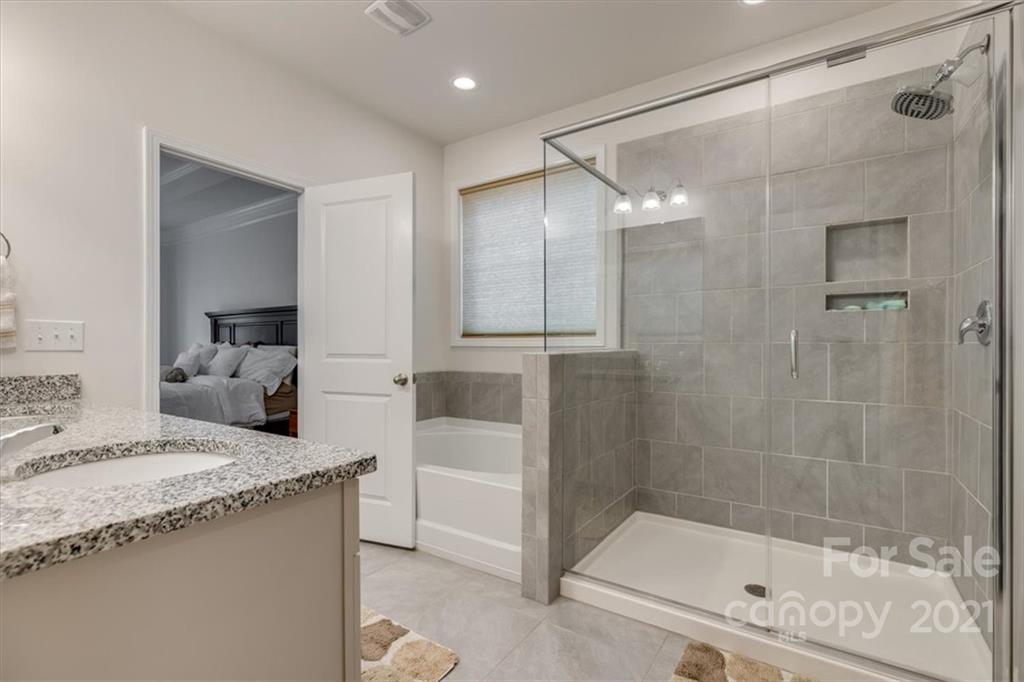 1007 Lydney Circle Waxhaw, NC 28173 - Photo 23 of 46 a bathroom with a granite countertop sink a mirror and shower