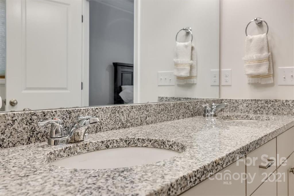 1007 Lydney Circle Waxhaw, NC 28173 - Photo 24 of 46 a bathroom with a granite countertop sink and a mirror