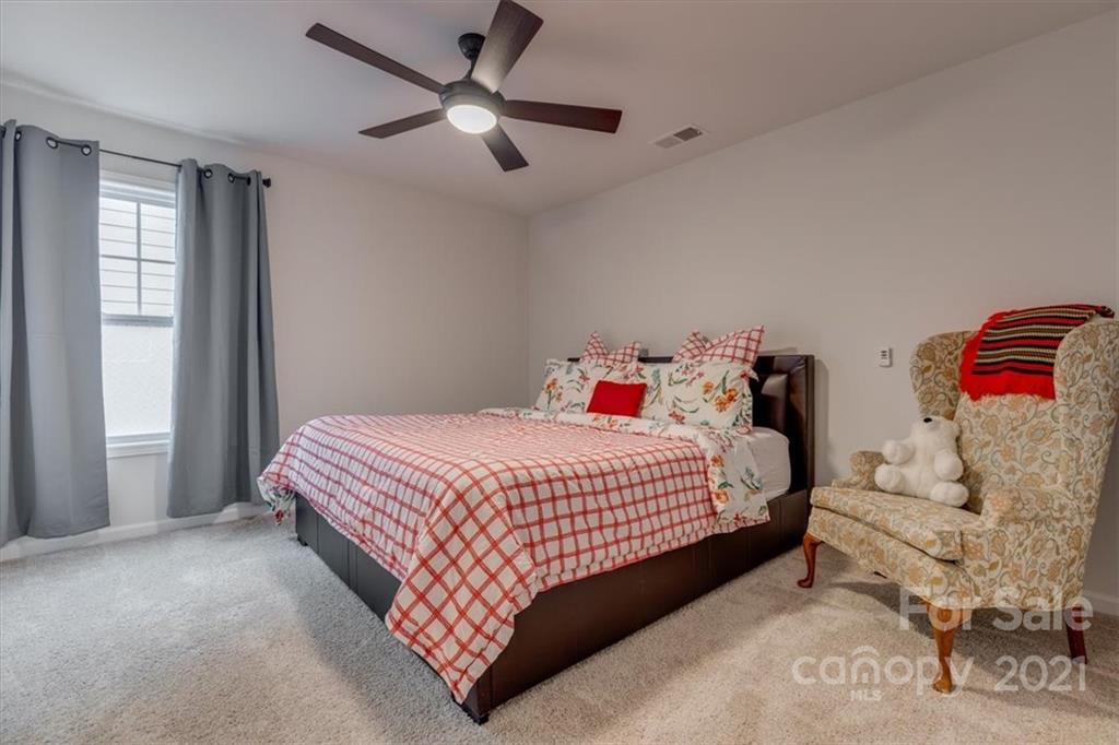 1007 Lydney Circle Waxhaw, NC 28173 - Photo 34 of 46 a bedroom with a bed and a chandelier