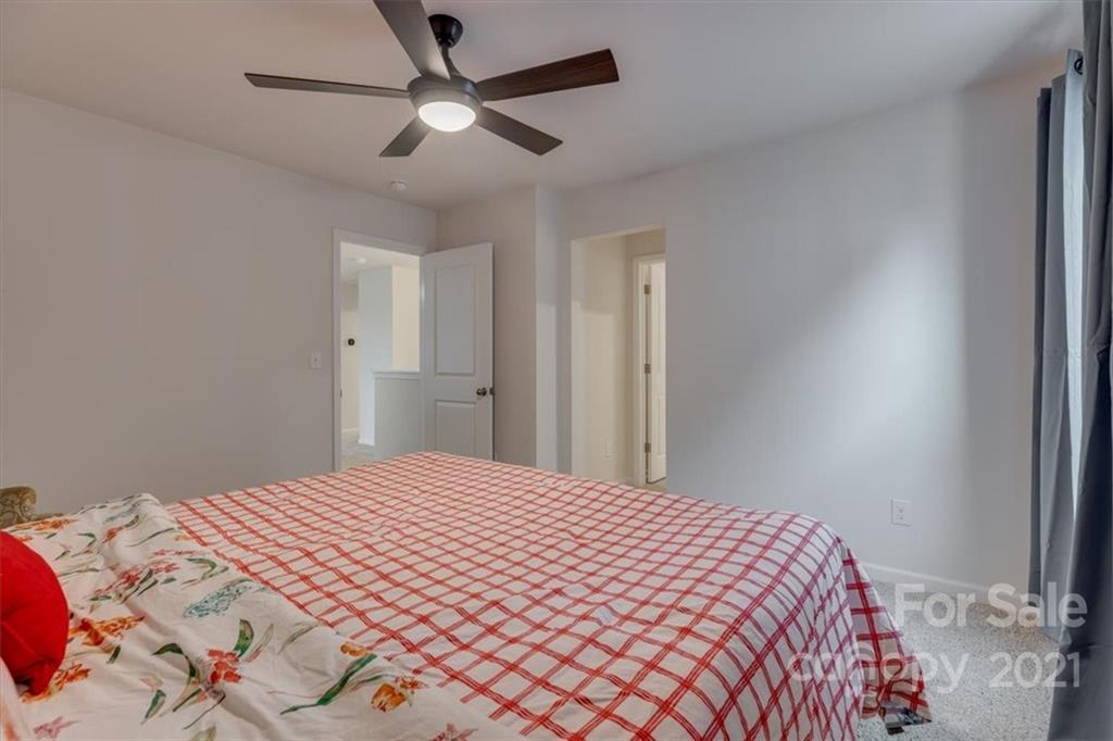 1007 Lydney Circle Waxhaw, NC 28173 - Photo 35 of 46 a bedroom with a large bed and a chandelier