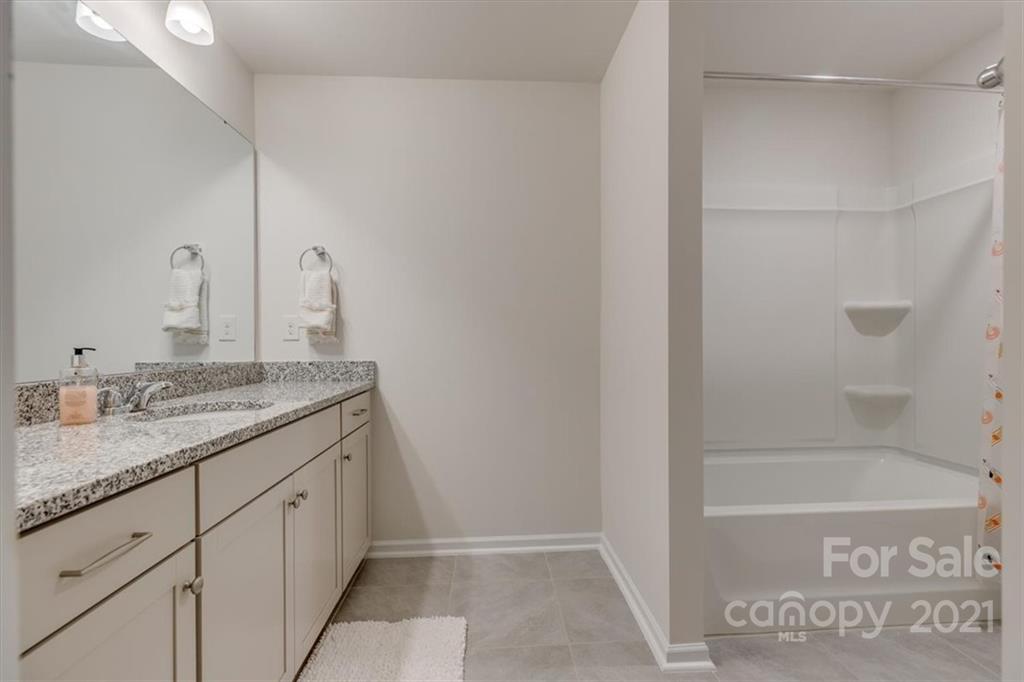 1007 Lydney Circle Waxhaw, NC 28173 - Photo 37 of 46 a bathroom with a granite countertop sink and a mirror