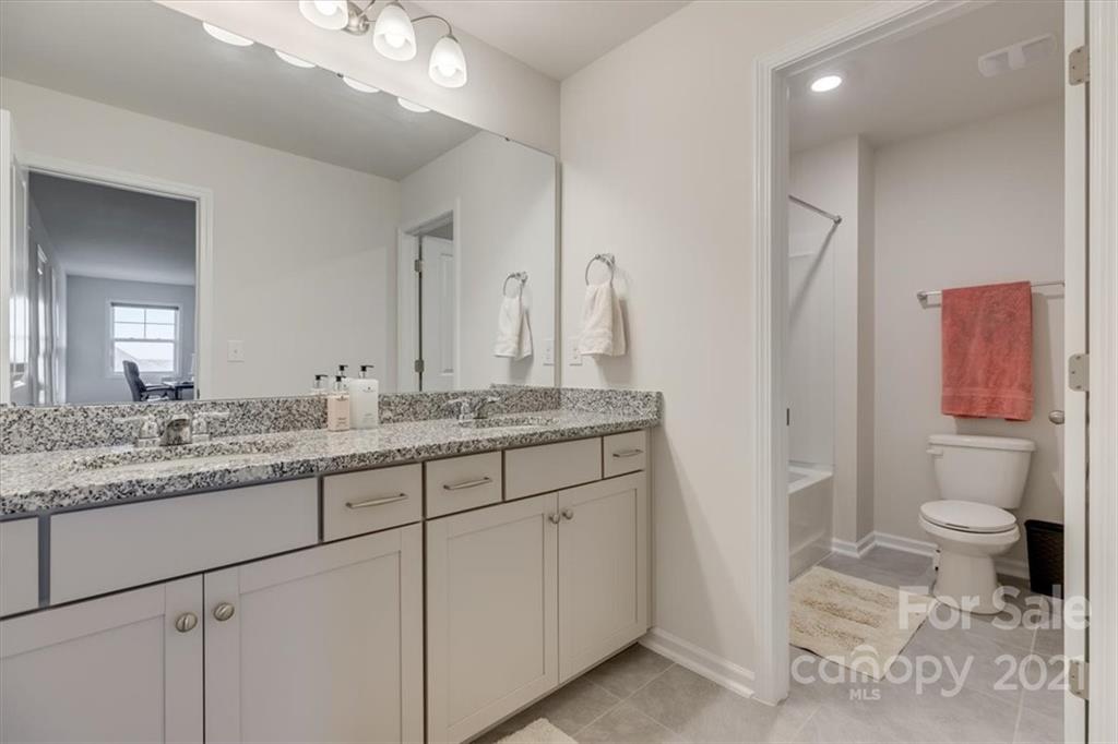 1007 Lydney Circle Waxhaw, NC 28173 - Photo 40 of 46 a bathroom with a granite countertop sink and a mirror