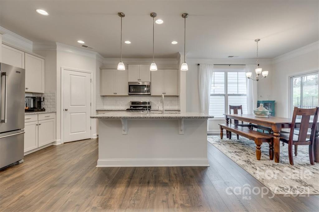 1007 Lydney Circle Waxhaw, NC 28173 - Photo 10 of 46 a open kitchen with stainless steel appliances granite countertop a stove a sink a refrigerator and white cabinets with wooden floor