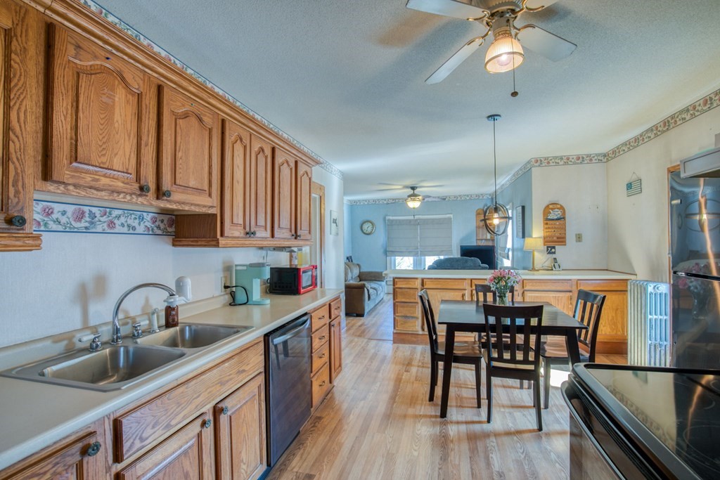 2129 Northampton Street Holyoke, MA 01040 - Photo 6 of 25 a kitchen with stainless steel appliances granite countertop a sink a stove and chairs with wooden floor