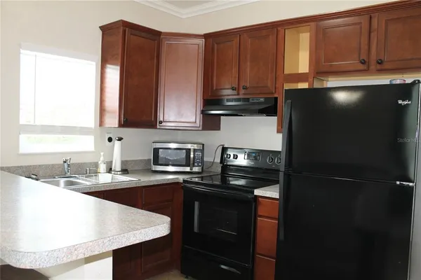 a kitchen with a sink a refrigerator and cabinets