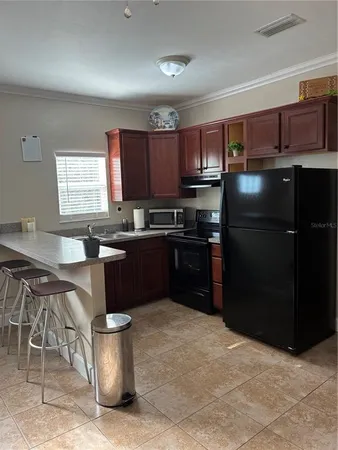 a kitchen with stainless steel appliances granite countertop a stove a sink dishwasher a refrigerator and a microwave