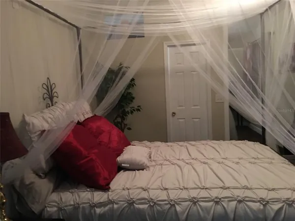a large bed sitting in a bedroom next to a larger window