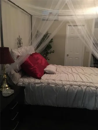 a bedroom with a bed and a night stand