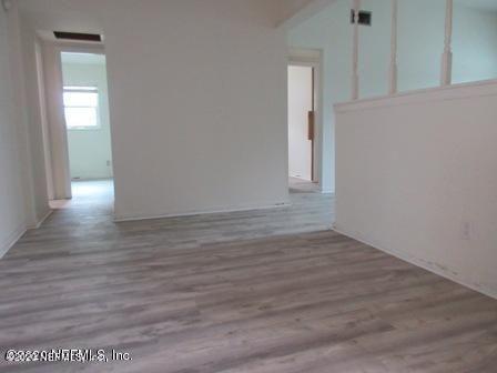 7655 Falcon Street Jacksonville, FL 32244 - Photo 2 of 13 a view of an empty room with wooden floor and a window