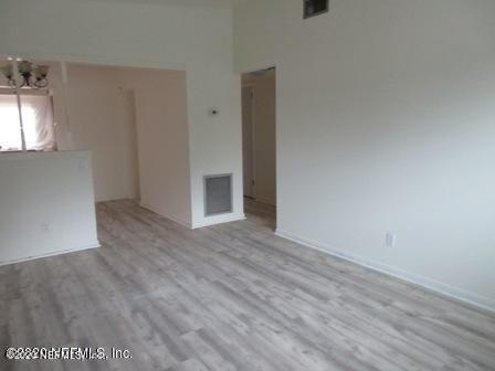 7655 Falcon Street Jacksonville, FL 32244 - Photo 7 of 13 an empty room with wooden floor and windows
