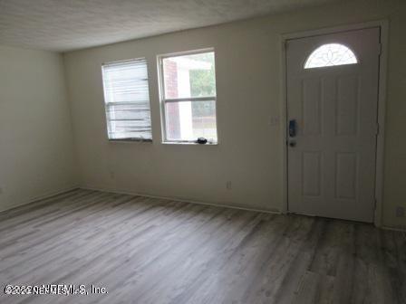7655 Falcon Street Jacksonville, FL 32244 - Photo 8 of 13 an empty room with wooden floor and windows