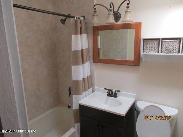 7655 Falcon Street Jacksonville, FL 32244 - Photo 10 of 13 a bathroom with a sink a mirror and a shower