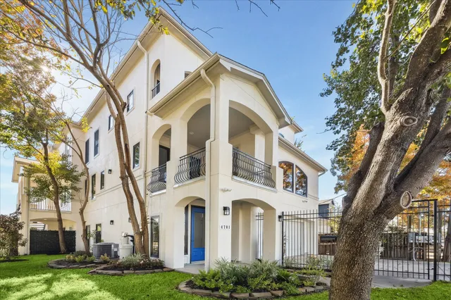 a front view of a white building with yard and green space