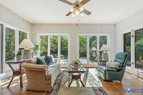 a dining room with furniture a chandelier and wooden floor