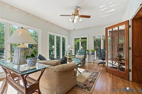 a dining room with furniture a chandelier and wooden floor