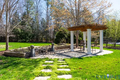 a view of a chair and table in backyard of the house