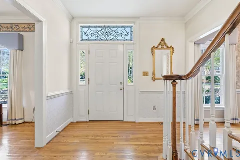 a view of a dining room with furniture a chandelier and wooden floor