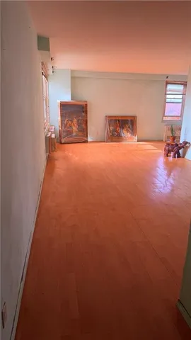 an empty room with a fireplace and wooden floor