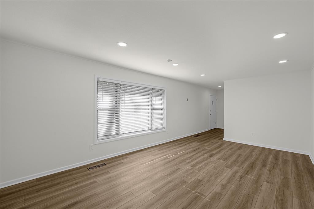 5201 Pine Avenue Waco, TX 76710 - Photo 5 of 33 an empty room with wooden floor and windows