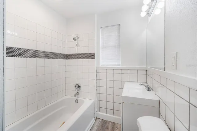 a bathroom with a bathtub shower sink vanity and toilet