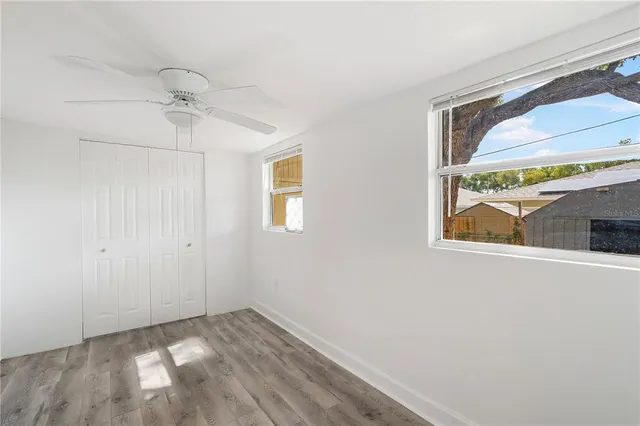 a view of empty room with window and ceiling fan